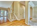 Bright foyer with hardwood floors, staircase, and neutral paint tones, creating a welcoming entrance at 2408 Eagleview Cir, Longmont, CO 80504