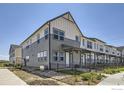 Modern townhome featuring gray and white siding, fenced front yard, and professional landscaping at 2763 Bear Springs Cir, Longmont, CO 80503