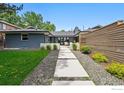 Landscaped front yard with walkway leading to a contemporary home featuring a gray brick exterior at 3275 19Th St, Boulder, CO 80304