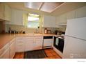 Functional kitchen featuring white cabinets, updated appliances, and a cozy breakfast nook at 3814 Columbia Dr, Longmont, CO 80503