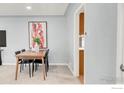 The dining area has a wooden table, with an abstract art decor, great space for gatherings at 4240 Harlan St, Wheat Ridge, CO 80033