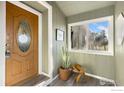 Charming entryway with wood-paneled walls, decorative window, and wood door at 4700 County Road 38, Platteville, CO 80651