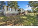 Charming home featuring a staircase to the front door, a walkout basement, and mature trees at 4700 County Road 38, Platteville, CO 80651