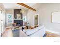 Inviting living room featuring a brick fireplace, hardwood floors, and exposed beam ceiling at 5326 Lowell Blvd, Denver, CO 80221
