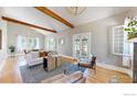 Bright living room with hardwood floors, exposed beams, and French doors leading to outdoor space at 5326 Lowell Blvd, Denver, CO 80221