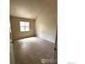 Tiled bedroom with a window providing natural light, freshly painted in neutral tones at 601 5Th St, Frederick, CO 80530