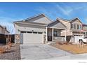 Beautiful home exterior featuring stone accents, a two-car garage, and a cozy front porch at 9873 Ceylon St, Commerce City, CO 80022