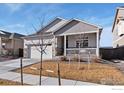 Attractive home exterior with a well-maintained lawn and a covered front porch at 9873 Ceylon St, Commerce City, CO 80022