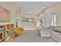 Cozy living room area with light colored walls and wood floors flowing into an open kitchen at 1050 Opal St # 203, Broomfield, CO 80020