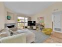 Inviting living space with a fireplace, sofa, and a view of the outdoor deck and neighborhood at 1050 Opal St # 203, Broomfield, CO 80020