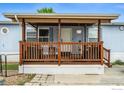 Front porch features seating, providing a cozy welcome to this charming home at 10573 Ashwood St # 334, Firestone, CO 80504