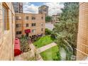 Multi-story apartment building with brick facade, green lawn, and sidewalks at 1100 Colorado Blvd # 305, Denver, CO 80206