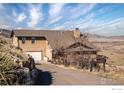 Lovely home shows views of the hills, a garage and a stone retaining wall at 11730 Pointe View Dr, Longmont, CO 80503