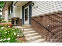 Close-up of the front porch showcasing the brick accents and flower garden at 13313 W Utah Cir, Lakewood, CO 80228