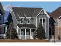 Gray two-story home with gabled roof, white trim, landscaping, and mountain views at 138 Westerly Blvd, Erie, CO 80516