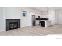 Bright, open living space with a modern fireplace and open kitchen with stainless steel appliances at 138 Westerly Blvd, Erie, CO 80516