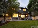 Beautiful backyard features a large patio with outdoor seating, a pergola, lush lawn, and stone accents at 1575 Kalmia Ave, Boulder, CO 80304
