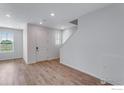 Bright living room featuring wood-look floors, a staircase, and a large window at 1776 Glacier Ave, Berthoud, CO 80513