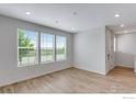 Open-concept living area with wood-look floors and large windows providing natural light at 1776 Glacier Ave, Berthoud, CO 80513