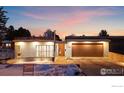 Well-lit modern home featuring a flat roof, sleek lines, a warm color palette, and a snow-covered yard at 2206 Alpine Dr, Boulder, CO 80304