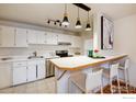 Bright kitchen with white cabinets, stainless steel appliances, and a breakfast bar with seating at 3240 Iris Ave # 201, Boulder, CO 80301