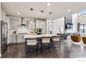 Modern kitchen features stainless steel appliances, an island with bar stools, and an open floor plan at 3315 Heron Lakes Pkwy, Berthoud, CO 80513
