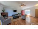 Cozy living room with a fireplace, hardwood floors, and neutral decor at 3598 Larkspur Dr, Longmont, CO 80503