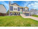 Charming two-story home with blue siding, a green front door, and landscaped front yard at 360 Wellington Ave, Lafayette, CO 80026