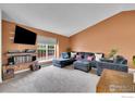 Comfortable living room with gray sofa, ottoman, large windows, and modern entertainment center at 360 Wellington Ave, Lafayette, CO 80026