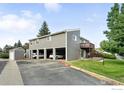 View of a two-story gray condo building with open carports, a wooden deck and green lawn at 3790 Iris Ave # D, Boulder, CO 80301