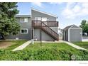 Two-story gray house with wooden deck and stairs, surrounded by green lawn and landscaping at 3790 Iris Ave # D, Boulder, CO 80301