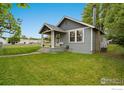 Quaint gray home with a cozy front porch, offering a welcoming curb appeal at 409 Main St, Mead, CO 80542
