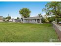 Sprawling lot with lush green grass and a detached garage offers ample space at 409 Main St, Mead, CO 80542