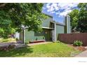 Green home with a well-manicured lawn, a hanging flower basket, and a cozy bench at 4129 Amber St, Boulder, CO 80304