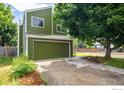 Charming home with green siding, a two-car garage, a mature tree, and a concrete driveway at 4129 Amber St, Boulder, CO 80304