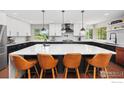 Modern kitchen features a large island, stainless steel appliances, and stylish pendant lighting at 5314 S Youngfield Ct, Littleton, CO 80127