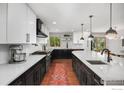 Spacious kitchen with white and black cabinets, large island, and hardwood floors at 5314 S Youngfield Ct, Littleton, CO 80127