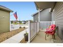 Inviting covered front porch with seating, a small picket fence, and low-maintenance gravel at 7840 Cattail Grn, Frederick, CO 80530