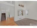 Open-concept living room featuring hardwood floors, staircase, and ample natural light at 940 Petras St, Erie, CO 80516