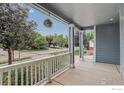 Inviting porch with white railing and columns, offering a scenic view of the neighborhood at 940 Petras St, Erie, CO 80516