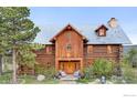 Inviting log cabin home with charming front porch and two chairs at 1050 Pine St, Boulder, CO 80302