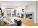 Cozy living room with a fireplace, hardwood floors, and a sliding glass door leading to a balcony at 1122 Olympia Ave # 12H, Longmont, CO 80504