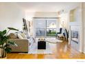 Bright living room featuring hardwood floors, a fireplace, and a sliding glass door to a balcony at 1122 Olympia Ave # 12H, Longmont, CO 80504