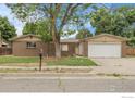 Charming single-story brick home with a well-maintained lawn and a two-car garage and mature trees at 11378 W 68Th Way, Arvada, CO 80004