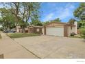Street view of a single-story home featuring a two-car garage, brick accents, and a well-maintained lawn at 11378 W 68Th Way, Arvada, CO 80004