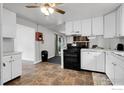 Bright kitchen with white cabinetry, black appliances, tile flooring and a view to backyard at 11378 W 68Th Way, Arvada, CO 80004