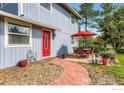 Inviting home exterior with a red front door and outdoor seating area, perfect for relaxation at 1240 Snowbank Ct, Longmont, CO 80504