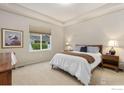 Comfortable bedroom boasts a queen-size bed, tray ceiling, and a view to the outside at 1531 Alpine Ave, Berthoud, CO 80513