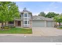Charming two-story home showcasing a three car garage, well-maintained lawn, and mature trees in a suburban setting at 2205 Keota Ln, Superior, CO 80027