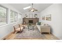 Cozy living area with a brick fireplace, built-in shelves, and large windows offering plenty of natural light at 2205 Keota Ln, Superior, CO 80027